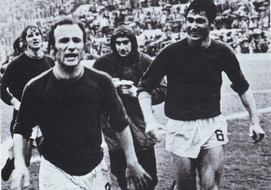 Francesco Rocca e Franco Peccenini immortalati al termine del “derby del sorpasso” del 23 marzo 1975, vinto 1-0 con gol di Prati. Alle spalle di Rocca si intravede un giovane Agostino Di Bartolomei