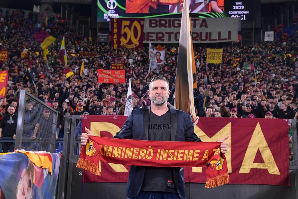 Candela con la sciarpa della Roma sotto la Curva Sud