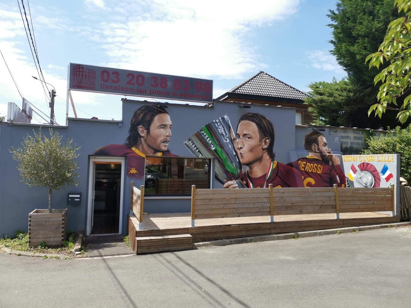 Il murales che accoglie i tifosi giallorossi al loro arrivo al Roma Club di Lille