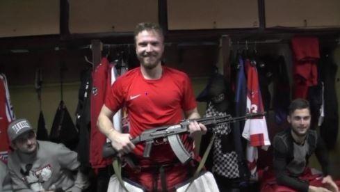 Saveli Kononov, il portiere dell'Izhstal Izhevsk sorridente con il kalashnikov in mano