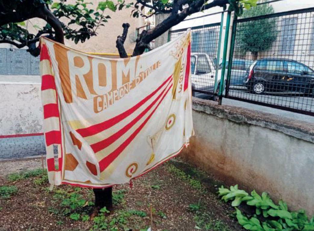 La storica bandiera prodotta in larga scala nel 1983 dopo il secondo scudetto della Roma, raffigurante la coppa delle Fiere e le coccarde delle coppe Italia vinte fino ad allora.