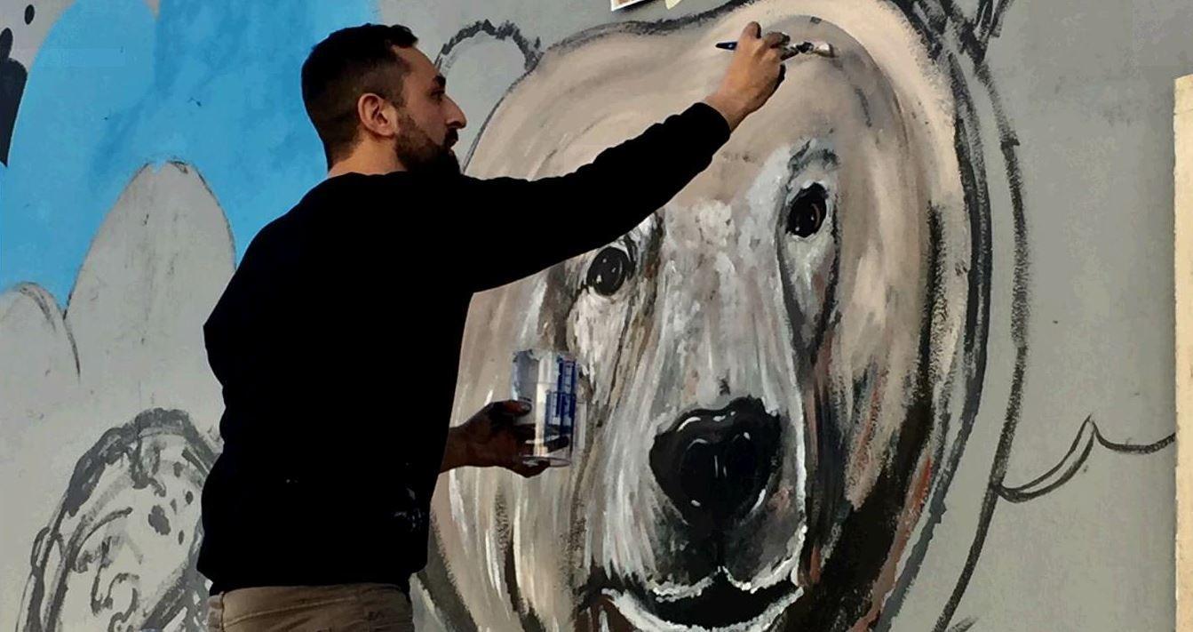 L’artista romano Matteo Brogi  al lavoro sul murales ecologico di San Lorenzo (Foto di Simone Santi) 