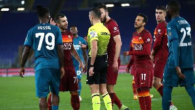 Henrikh Mkhitaryan e Bryan Cristante chiedono spiegazioni all’arbitro Guida dopo il clamoroso rigore negato nel finale della gara contro il Milan