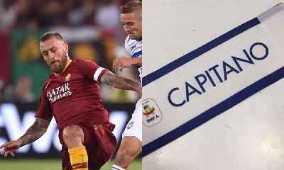 A sinistra, De Rossi durante Roma-Ataltana. A destra, la fascia della Lega Serie A