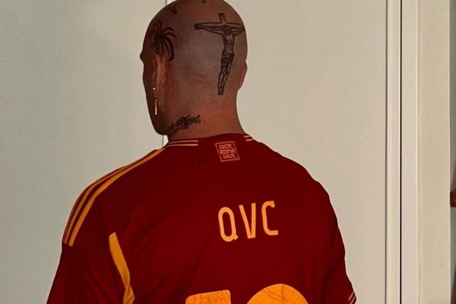 Gemitaiz in posa con una maglia della Roma