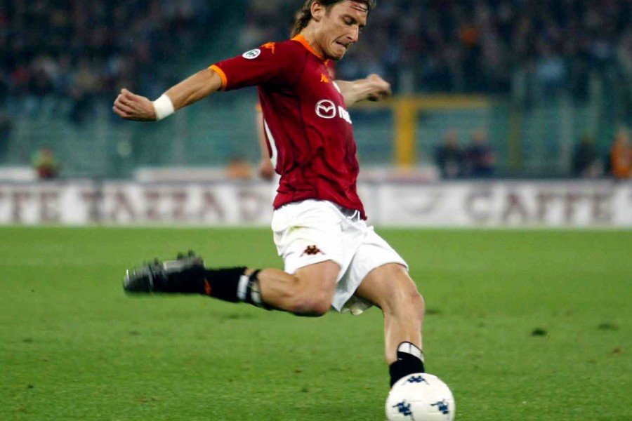 Totti mentre calcia un pallone con la maglia della Roma