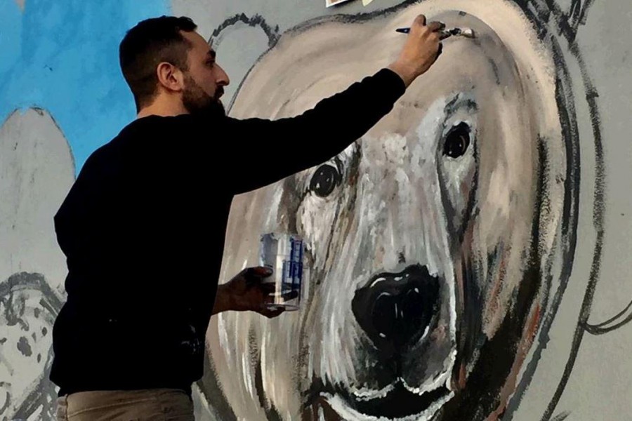 L’artista romano Matteo Brogi  al lavoro sul murales ecologico di San Lorenzo (Foto di Simone Santi)