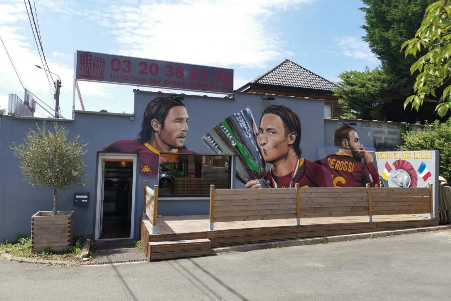 Il murales che accoglie i tifosi giallorossi al loro arrivo al Roma Club di Lille