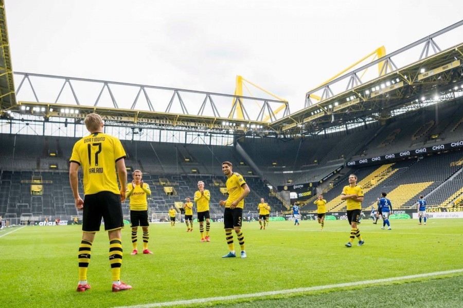 I calciatori del Borussia Dortmund festeggiano a distanza il gol dell'1-0 contro lo Schalke 04