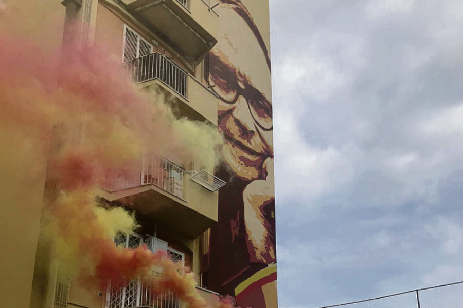 Il murale per Ennio Morricone con dei fumogeni giallorossi