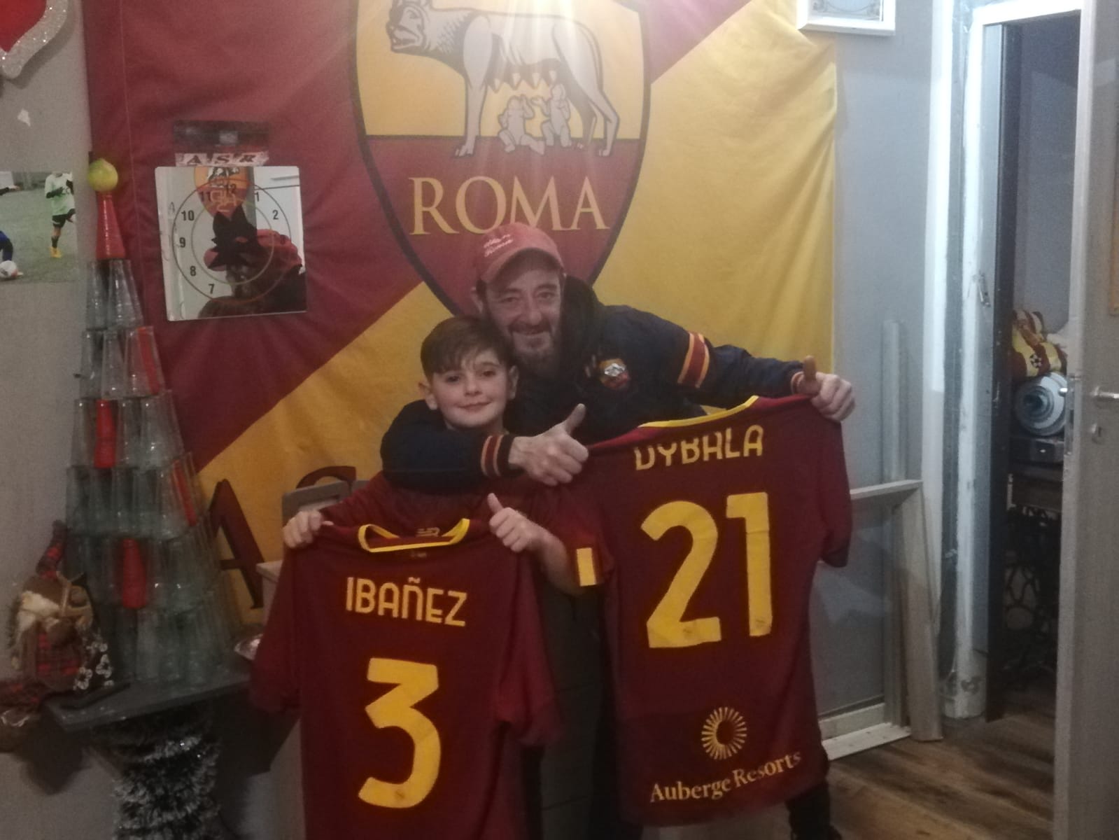 Flavio e il papà posano con le maglie donate dai calciatori giallorossi