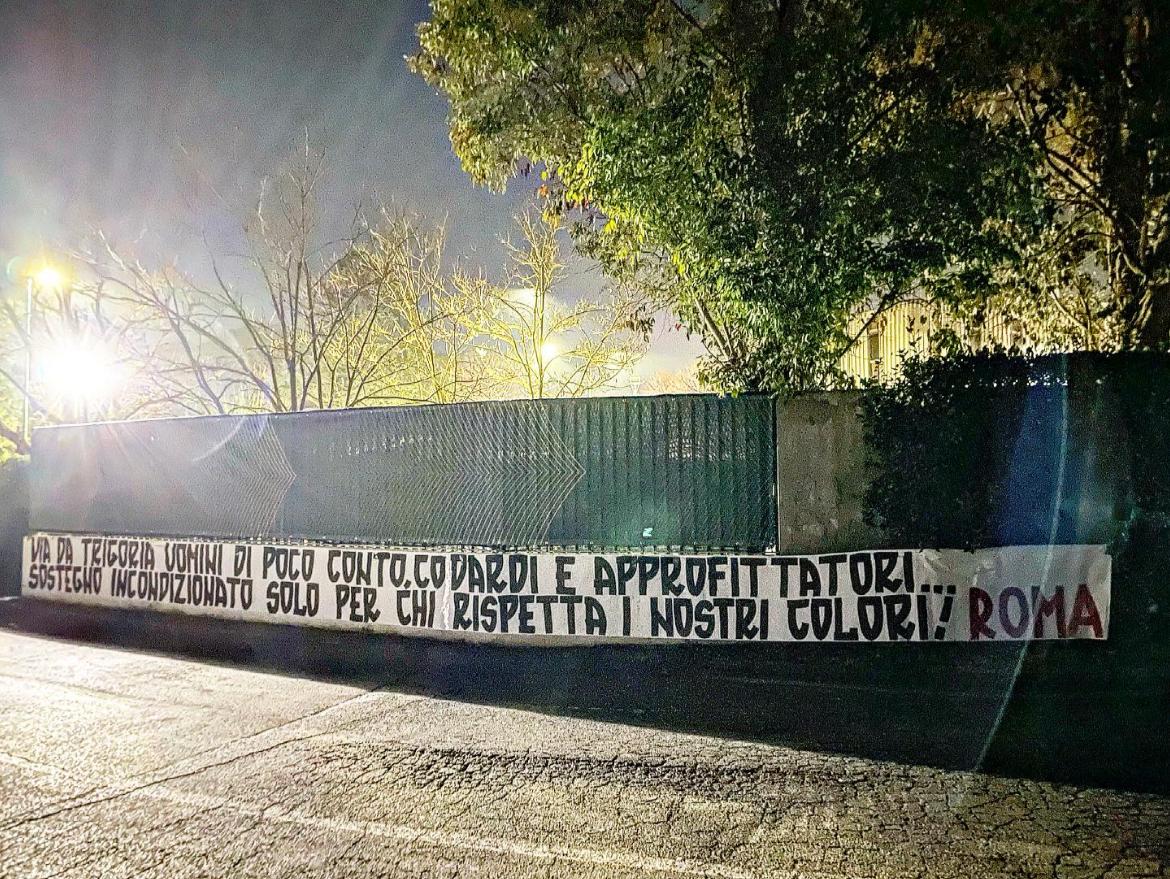 Lo striscione esposto dai tifosi della Roma a Trigoria