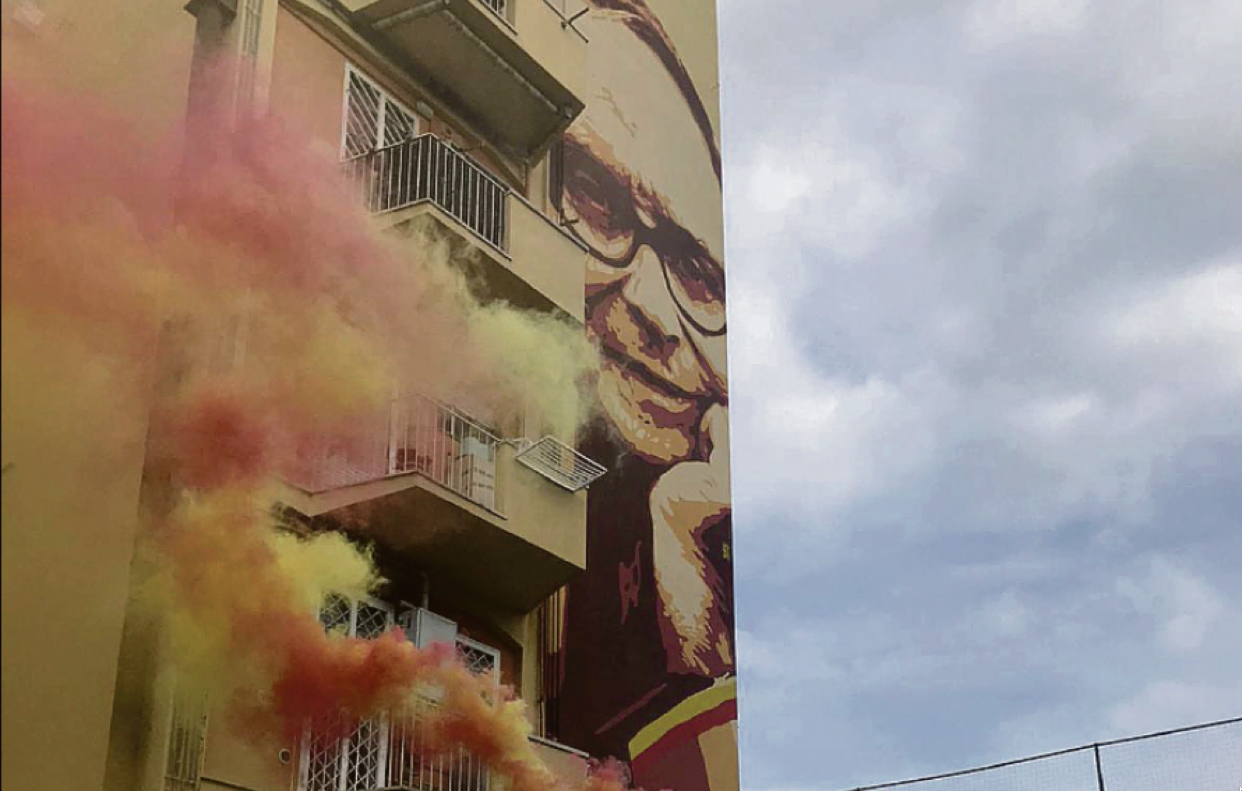 Il murale per Ennio Morricone con dei fumogeni giallorossi